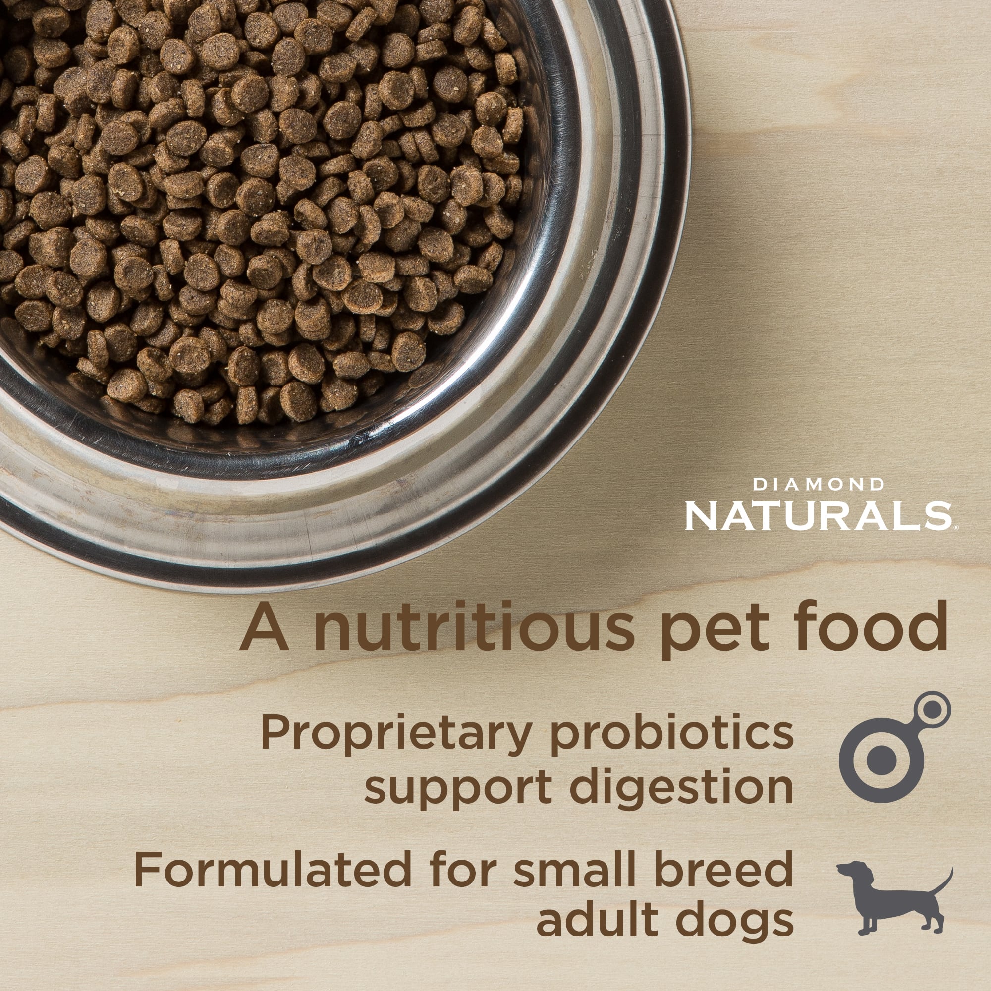 A metal bowl full of Diamond Naturals Small Breed Adult Dog Chicken & Rice Formula kibble.
